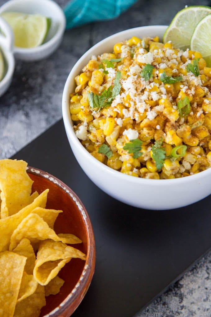 Mexican Street Corn being served a dip with tortilla chips 