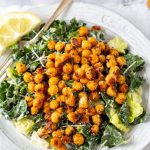 Romaine and Kale Caesar salad with crunchy Parmesan roasted chickpeas on a white plate with silver fork
