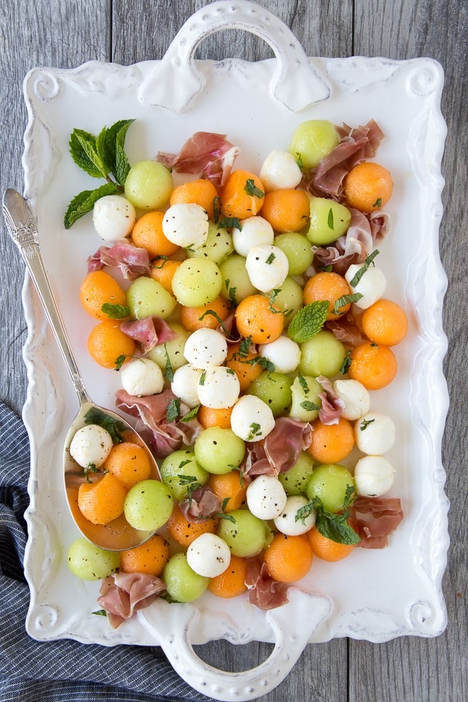 Summer Melon & Prosciutto Salad on a white platter