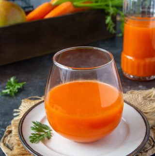 fresh carrot apple juice in a clear glass