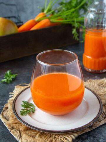 fresh carrot apple juice in a clear glass