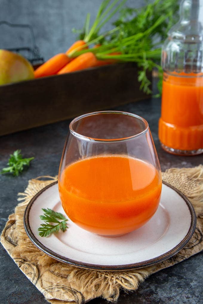fresh carrot apple juice in a clear glass 