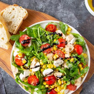 Tuna salad on a white plate next to bread slices